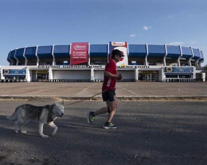 Un hombre trota frente al estadio Corregidora en Querétaro, México, el domingo 6 de marzo de 2022. (AP Foto/Marco Ugarte)