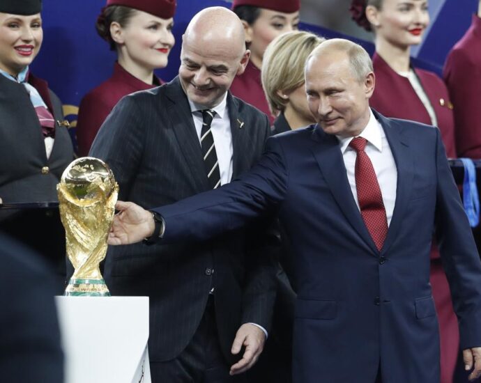 ARCHIVO - El presidente ruso Vladimir Putin toca la Copa del Mundo junto al líder de la FIFA Gianni Infantino, el domingo 15 de julio de 2018, al concluir la final entre Francia y Croacia (AP Foto/Petr David Josek)