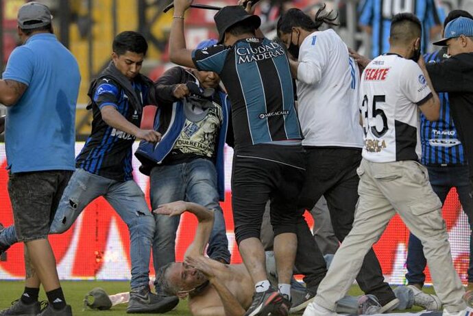 Aficionados del Querétaro y del Atlas riñen durante un partido de la Liga MX, el sábado 5 de marzo de 2022, en el Estadio Corregidora de Querétaro. (AP Foto/Sergio González)