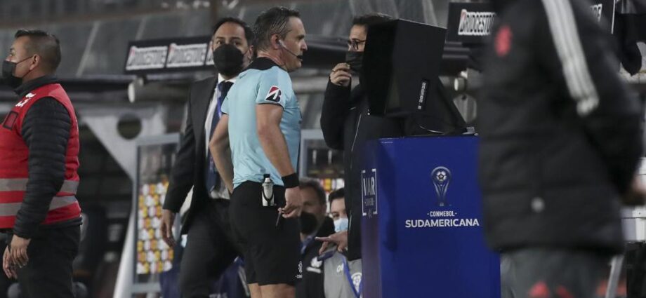 El árbitro Patricio Loustau de Argentina revisa el VAR durante un partido de la Copa Sudamericana en Santiago, Chile, el martes 28 de junio de 2022. (AP Foto/Luis Hidalgo)