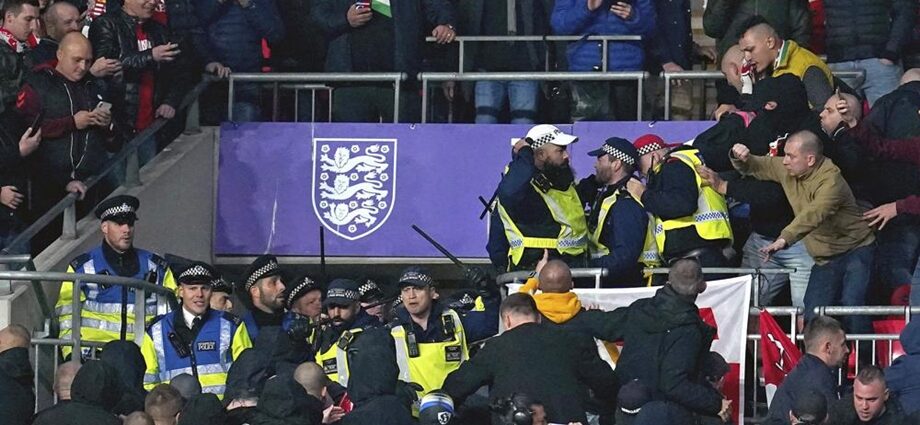 Aficionados húngaros chocan con la policía en las gradas del estadio Wembley durante el partido de las eliminatorias europeas a la Copa del Mundo entre Hungría e Inglaterra, en Londres, el martes 12 de octubre de 2021. (Nick Potts/PA vía AP)