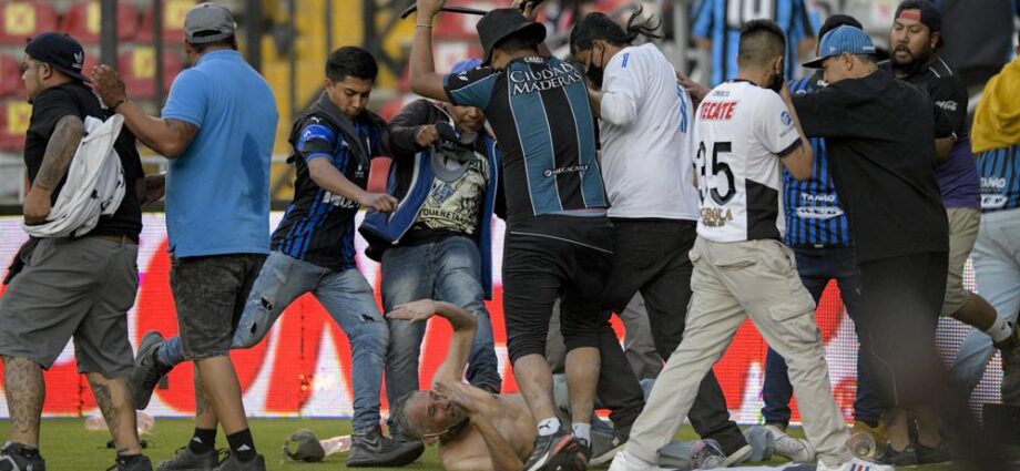 Aficionados del Querétaro y del Atlas riñen durante un partido de la Liga MX, el sábado 5 de marzo de 2022, en el Estadio Corregidora de Querétaro. (AP Foto/Sergio González)