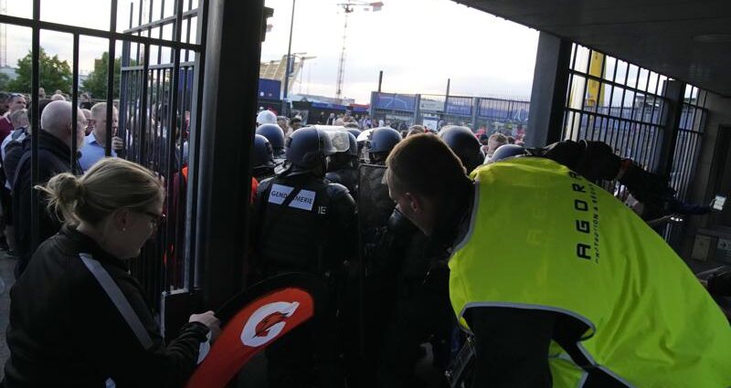En foto del sábado 28 de mayo del 2022, la policía y guardias de seguridad bloquean uno de los accesos en el Stade de France antes de la final de la Liga de Campeones. (AP Foto/Christophe Ena)