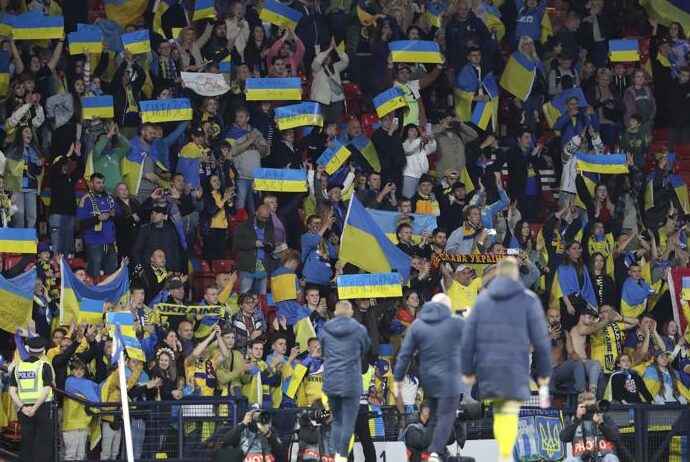 Aficionados de Ucrania sostienen banderas del país al final del partido de la Liga de las Naciones en el estadio Hampden Park en Glasgow, Escocia, el miércoles 21 de septiembre de 2022. (AP Foto/Scott Heppell)